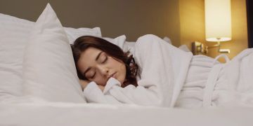 Frau schläft in Hotelbett