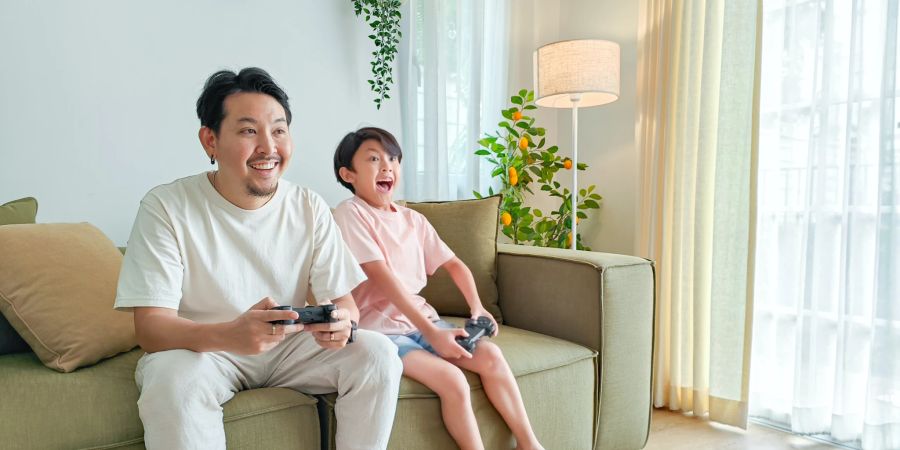 Mann und Junge spielen Videospiele