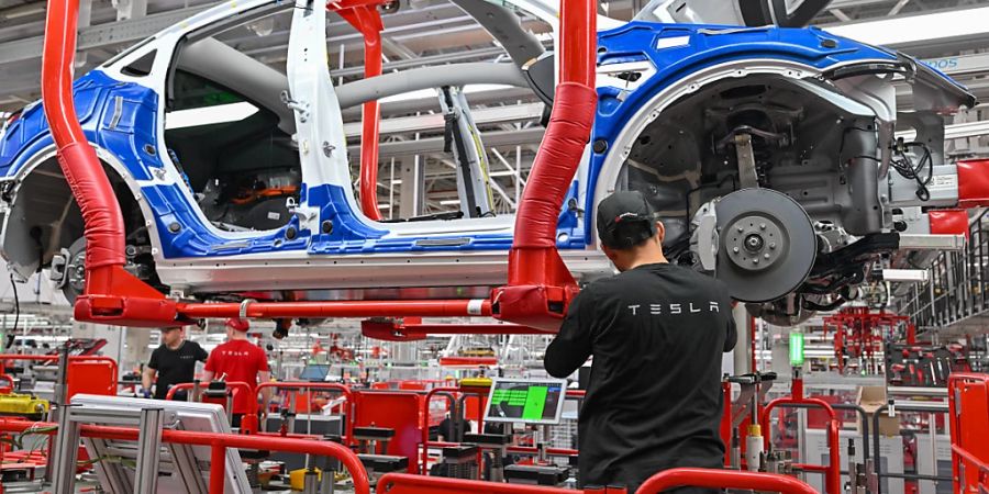 ARCHIV - Ein Mitarbeiter der Tesla Gigafactory Berlin Brandenburg arbeitet an einer Fertigungslinie eines Elektrofahrzeuges vom Typ Model Y. Foto: Patrick Pleul/dpa