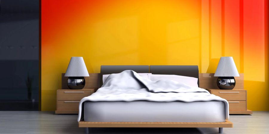 Schlafzimmerbett mit Nachtschränken vor orangefarbener Wand mit Farbverlauf