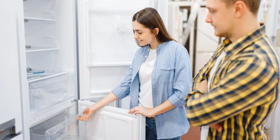 Frau und Mann stehen vor Kühlschrank