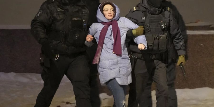 dpatopbilder - Polizeibeamte halten eine Frau fest, die Blumen für den verstorbenen russischen Oppositionellen Nawalny niederlegt hat. Foto: Uncredited/AP/dpa