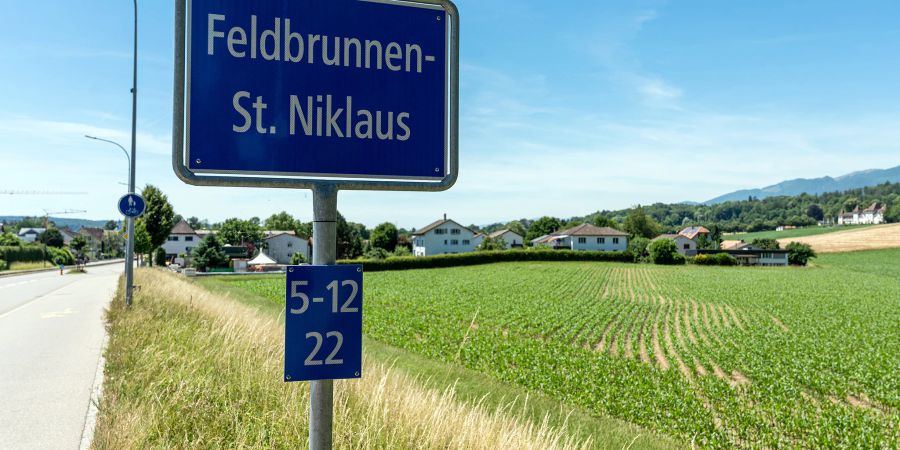 Die Ortstafel von Feldbrunnen St. Niklaus an der Baselstrasse. Ganz hinten rechts das Schloss Waldegg.