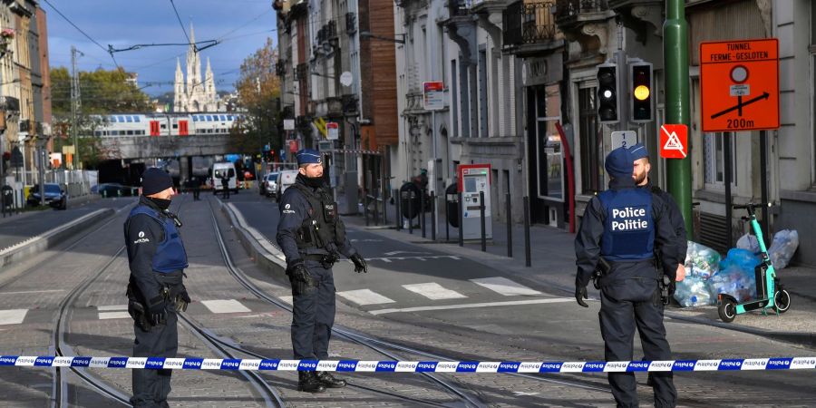 Belgische Polizeibeamte in einem abgesperrten Bereich am Tatort in Brüssel.