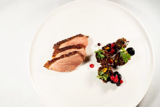 Entenbrust-Stücke in ungerader Zahl bilden den Kontrast zu Primeur-Rüben, Johannisbeeren, Lavendel und Pfeffer. Gericht Ente Teller Anrichtung Gourmet