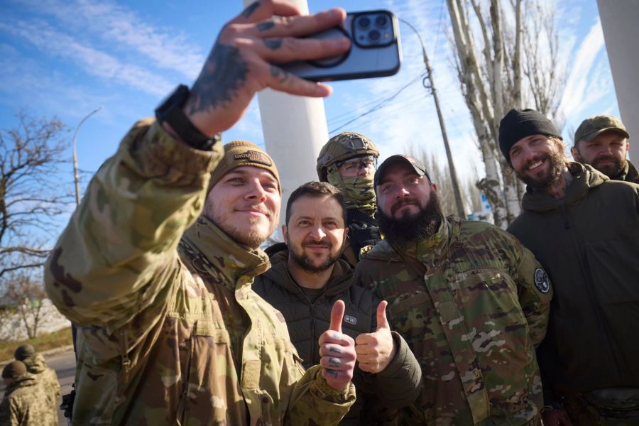 Ukrainische Soldaten machen ein Selfie mit dem ukrainischen Präsidenten Wolodymyr Selenskyj während seines Besuchs in Cherson.