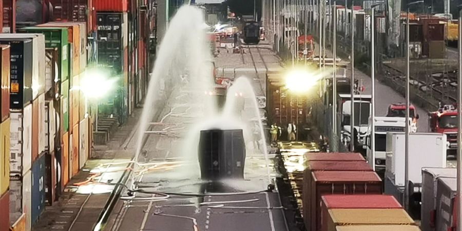 Nach einem Chemieunfall im Mühlauhafen kühlt die Feuerwehr einen Container, der mit rund 200 Fässern Hydrosulfit gefüllt ist.