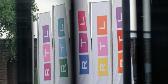 Fahnen des Fernsehsenders RTL auf dem Platz vor dem Firmengebäude.