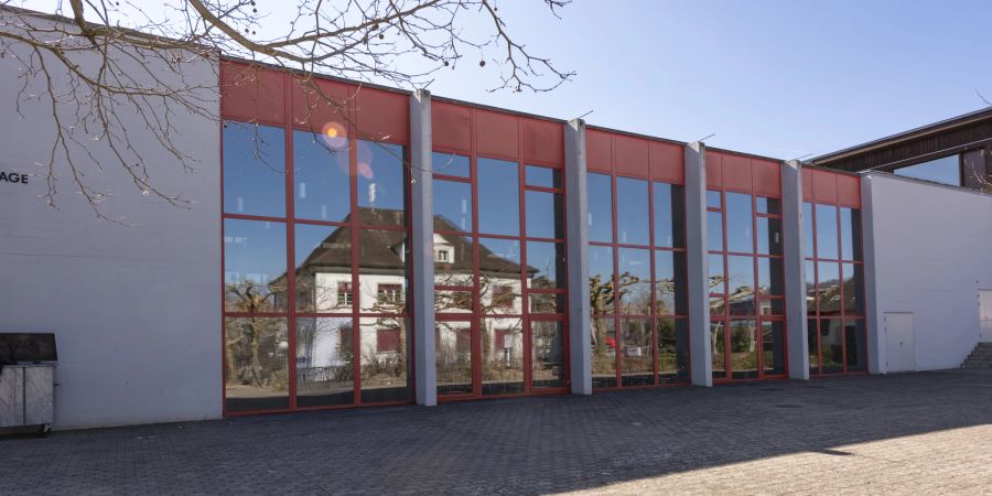 Das Gemeindehaus Mägenwil spiegelt sich in der Fensterfront des Schulhauses Oberfeld.