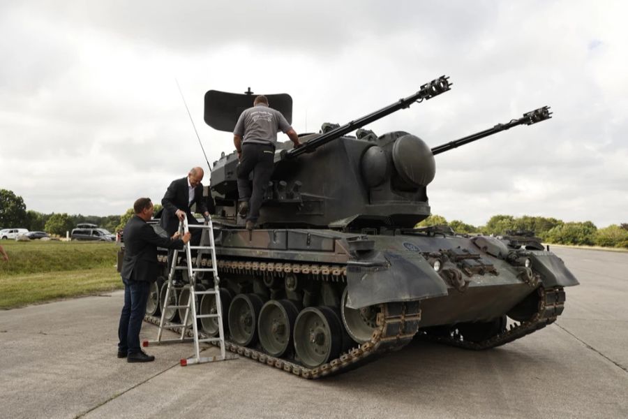 Scholz klettert auf den Luftabwehrpanzer mithilfe einer Leiter.