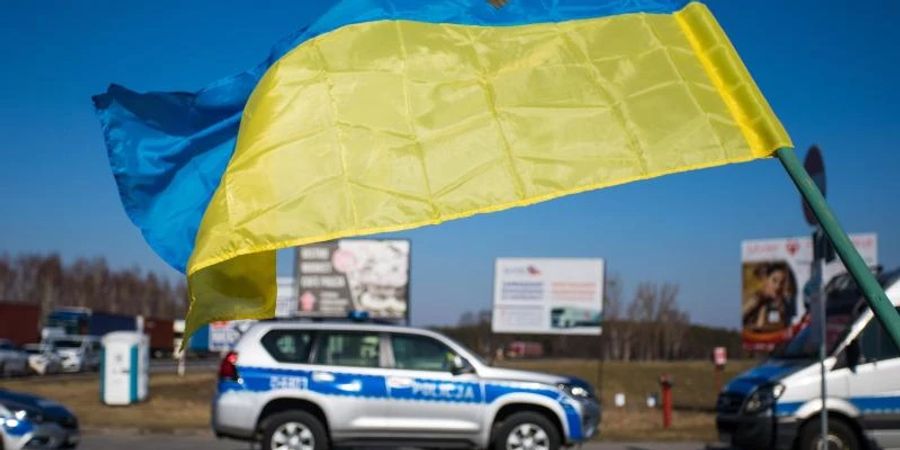 Eine ukrainische Landesfahne ist am polnisch-belarussischen Grenzübergang Koroszczyn zu sehen. Foto: Bartlomiej Wojtowicz/PAP/dpa