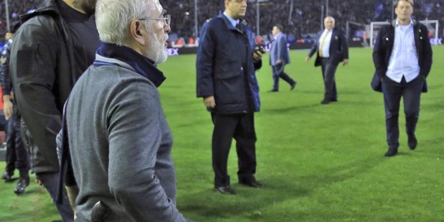 Iwan Savvidis (vorne), Besitzer und Präsident des Fussballclubs Paok Saloniki, geht mit einer Waffe am Gürtel auf den Platz. Foto: Uncredited/InTime Sports/AP/dpa