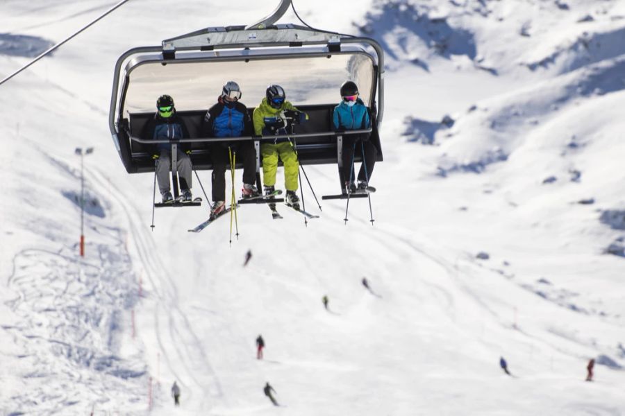 Skifahrer mit Schutzmaske auf dem Sessellift, aufgenommen zum Start der Ski Vorsaison auf Parsenn, am Samstag, 6. November 2021, in Davos.