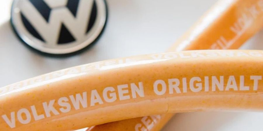 Eine Wurst mit der Aufschrift «Volkswagen Originalteil». Foto: picture alliance / dpa