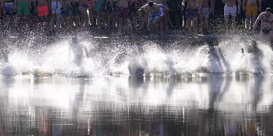 Christlich-Orthodoxe Gläubige springen während des traditionellen Dreikönigsfestes in das kalte Wasser des Becmen-Sees in Serbien. Foto: Darko Vojinovic/AP/dpa