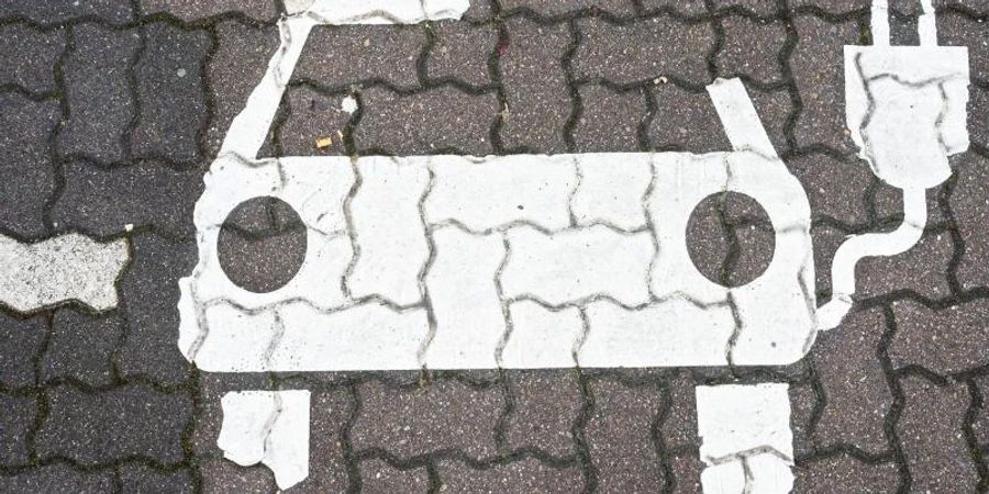 Ein Symbol markiert einen Parkplatz für Elektroautos an Ladesäulen für E-Auto an einem Rastplatz. Foto: Julian Stratenschulte/dpa