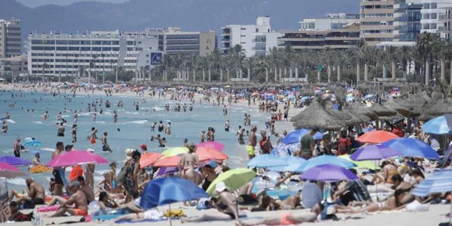 Touristen am Strand von Arenal. Corona-Reisebeschränkungen werden auf Mallorca deutlich gelockert oder fallen ganz. Foto: Clara Margais/dpa