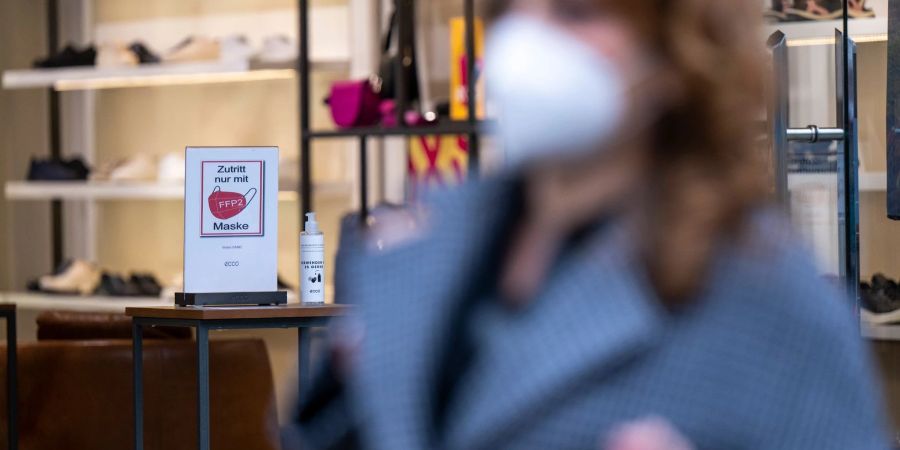Ein Schild am Eingang eines Schuh-Geschäfts weist auf die Pflicht zum Tragen einer FFP2-Maske hin.