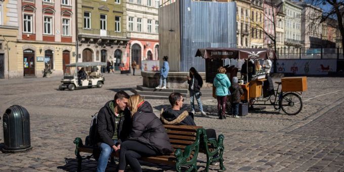 Ein küssendes Paar sitzt in der Innenstadt von Lwiw auf einer Bank. Ein küssendes Paar sitzt in der Innenstadt von Lwiw auf einer Bank.