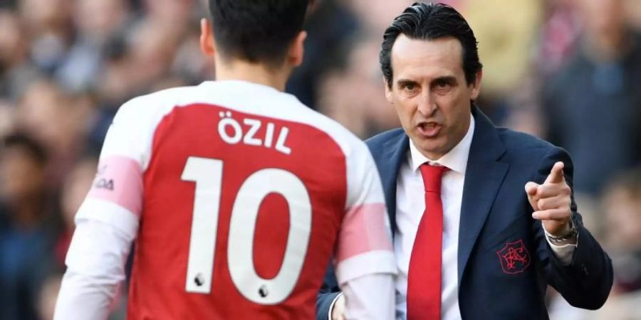 Arsenal-Trainer Unai Emery (r) gibt während eines Spiels Mesut Özil Anweisungen. Foto: Joe Giddens/PA Wire/dpa