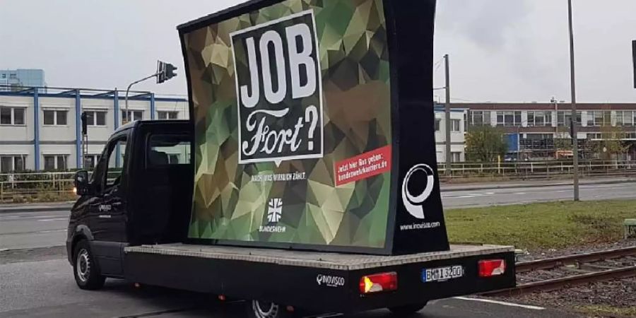 Ein Lieferwagen mit der Bundeswehr-Anzeige fährt am Ford-Werk in Köln vorbei. Foto: Ford