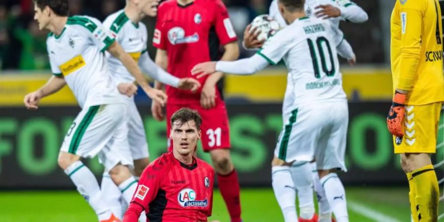 Die Gladbacher Spieler freuen sich im Hintergrund über den Treffer zum 1:1-Ausgleich gegen Freiburg. Foto: Marcel Kusch