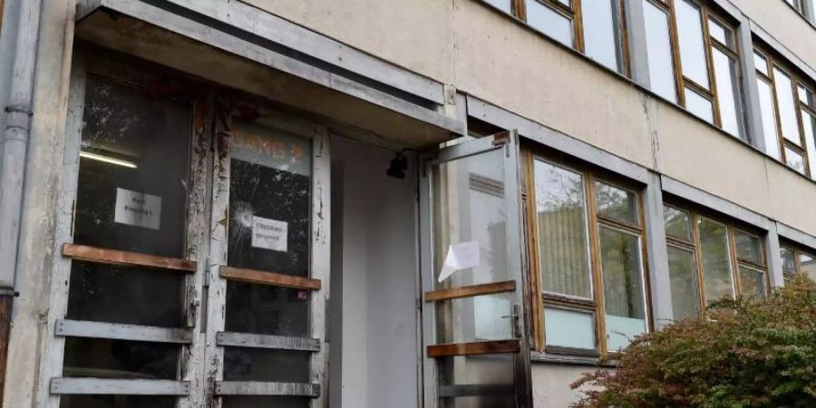 2015: Brandspuren und eine beschädigte Scheibe an einem als Flüchtlingsunterkunft vorgesehenen Gebäude in Dresden. Foto: Bernd Settnik