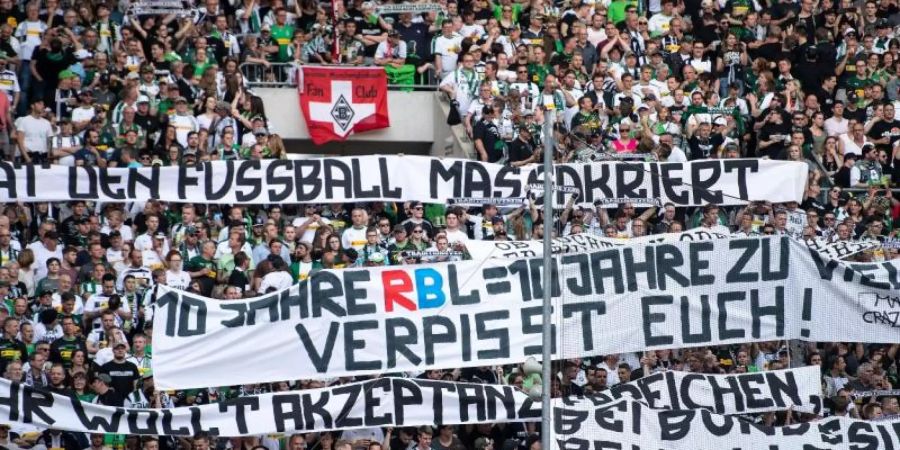 Gladbacher Fans halten vor der Partie gegen RB Leipzig diffamierende Banner in die Höhe. Foto: Marius Becker