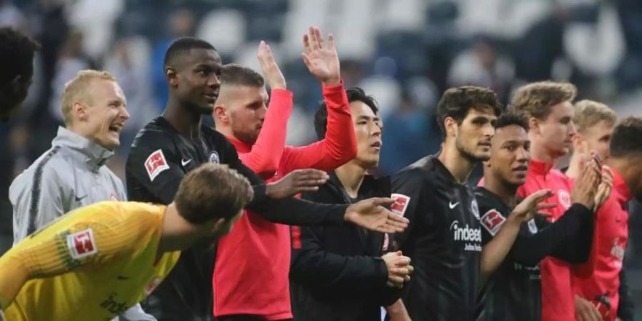 Die Frankfurter Spieler feiern mit den Fans den 3:0-Sieg im Spiel gegen den VfB. Foto: Thomas Frey/dpa