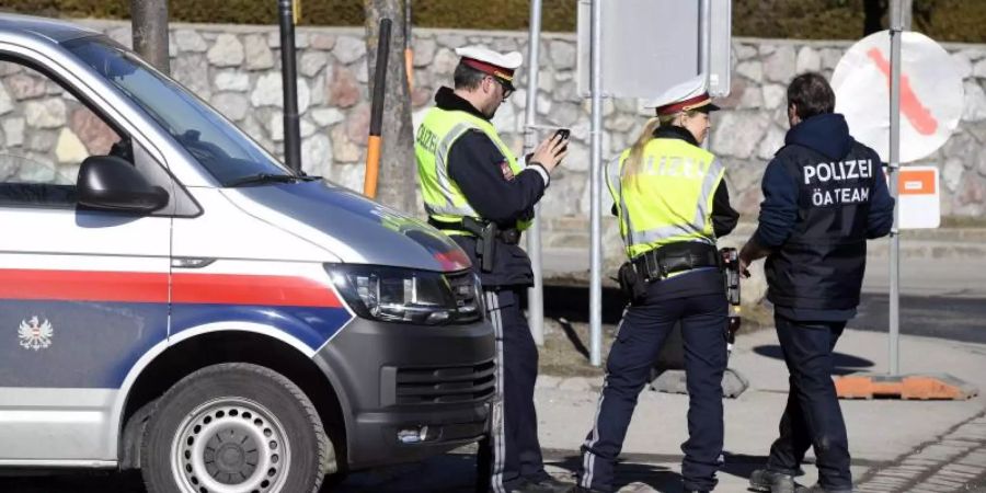 Österreichische Polizisten stehen im Rahmen einer Doping-Razzia neben ihrem Einsatzwagen. Foto: Heikki Saukkomaa/Lehtikuva