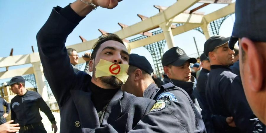 Polizisten mit demonstrierendem Journalisten in Algier