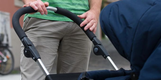 Ein junger Vater mit einem Kinderwagen (Symbolbild). Ein junger Vater mit einem Kinderwagen (Symbolbild).