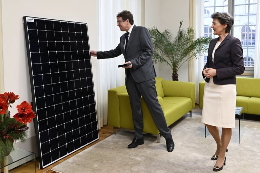 Die zurückgetretene Bundesrätin Simonetta Sommaruga schenkt anlässlich der Schlüsselübgabe ihrem Nachfolger im UVEK, Bundesrat Albert Rösti, ein Solarmodul.