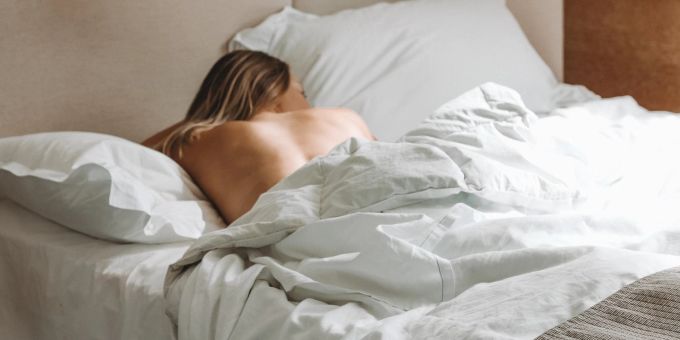 Es gibt Vor- und Nachteile, nackt zu schlafen. Frau im Bett
