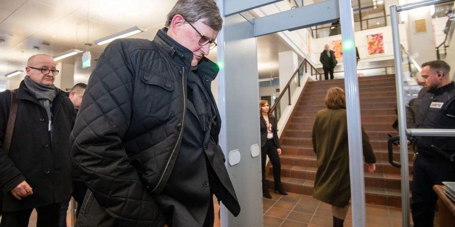 Kardinal Rainer Maria Woelki wartet im Foyer des Landgerichts vor der Sicherheitsschleuse.