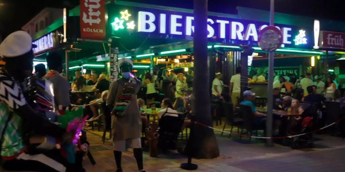 Strassenverkäufer stehen am 12. juli vor dem von Touristen gut besuchten Lokal "Las Palmeras" in der so genannten Bierstrasse. (Archivbild) Foto: Clara Margais Tourismus auf Mallorca Coronavirus