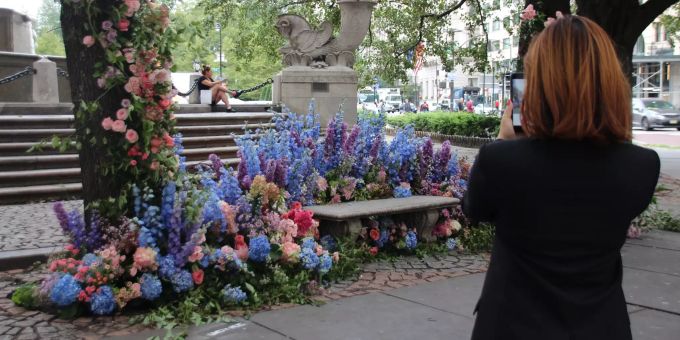 Eine Frau fotografiert die an der Fifth Avenue in New York angebrachten Blumen an einem Brunnen. Gedenken an «9/11»