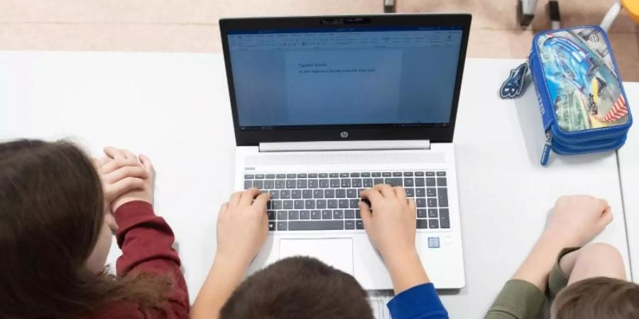 Schüler einer 3. Klasse sitzen während eines Presserundgangs in einem Klassenzimmer der Grundschule Georgius Agricola vor einem Laptop. Foto: Sebastian Kahnert/dpa-Zentralbild/dpa