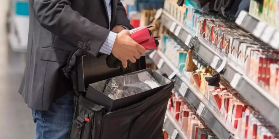 Ein Detektiv einer Sicherheitsfirma demonstriert, wie Ladendiebe mit Hilfe eines präparierten Koffers die Sicherungsetiketten an der Ware überlisten können. Foto: Boris Roessler/dpa