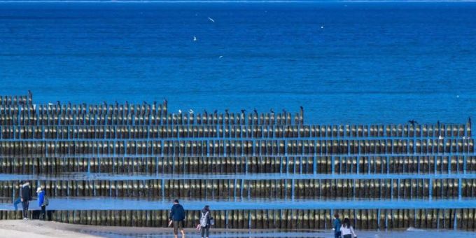 Spaziergänger am Strand von Koserow auf der Ostseeinsel Usedom. Foto: Jens Büttner/dpa-Zentralbild/dpa Spaziergänger am Strand von Koserow auf der Ostseeinsel Usedom. Foto: Jens Büttner/dpa-Zentralbild/dpa