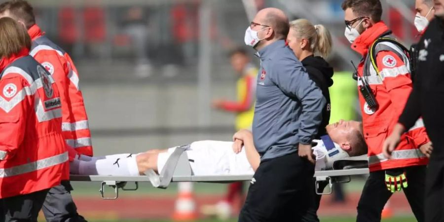 Denis Linsmayer wird verletzt vom Platz getragen. Foto: Daniel Karmann/dpa