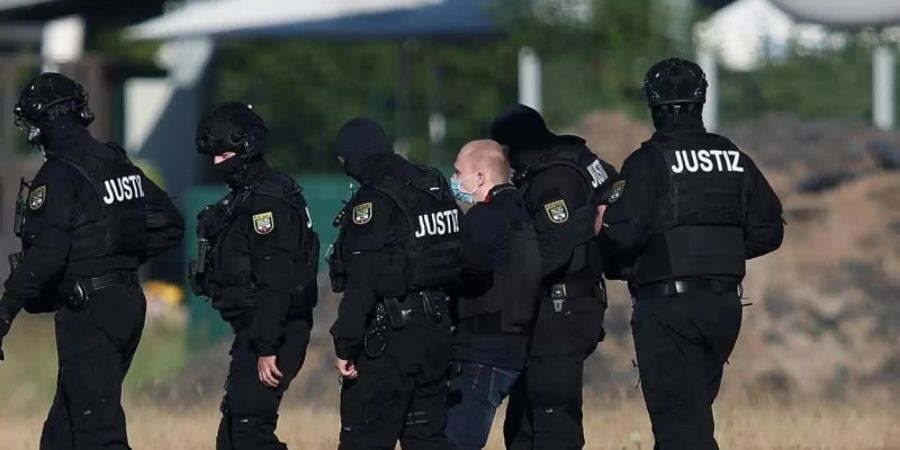 Der Angeklagte Stephan Balliet wird vor dem vierten Prozesstag von Justizbeamten aus dem Hubschrauber gebracht. Foto: Ronny Hartmann/dpa