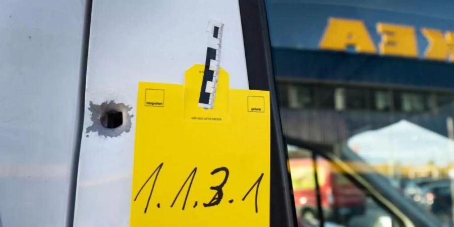 Ein von der Spurensicherung gekennzeichnetes Einschussloch vor einem Seiteneingang eines Ikea-Möbelhauses. Foto: Frank Rumpenhorst/dpa