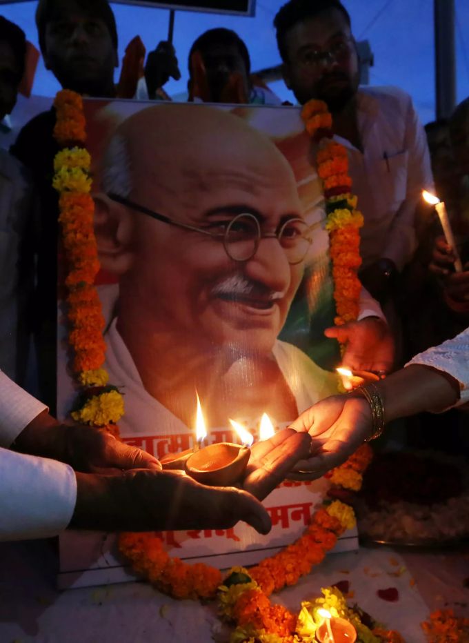 Leute feiern am Abend vor dem 150. Geburtstag von Mohandas Karamchand Gandhi. Mohandas Karamchand Gandhi