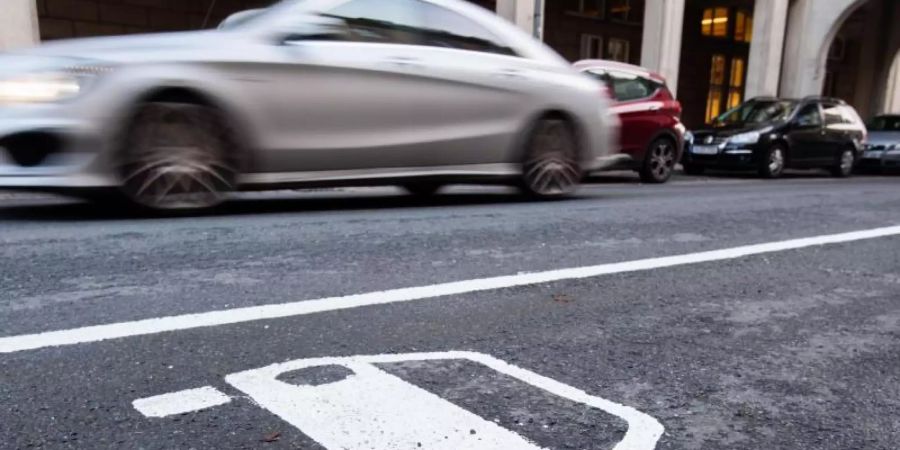Ein Symbol eines Elektroautos markiert einen Parkplatz neben einer E-Ladesäule. Foto: Julian Stratenschulte/dpa