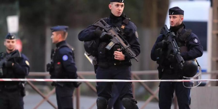 Schwerbewaffnete Polizisten sichern den Tatort nach der Messerattacke. Foto: Michel Euler/AP/dpa