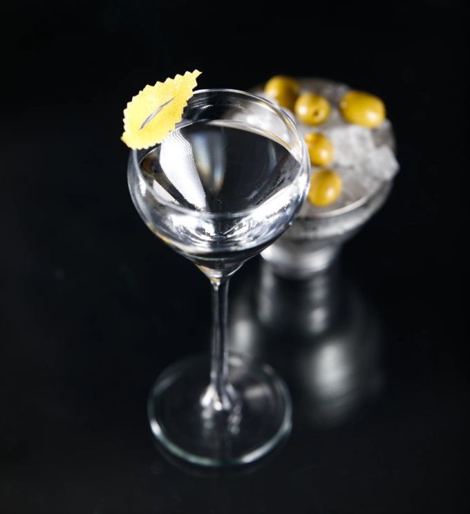 Der Gin Martini ist die kräftigere Variante. Er enthält mehr Gin als Wermut. Gin Glas Zitrone schwarz durchsichtig