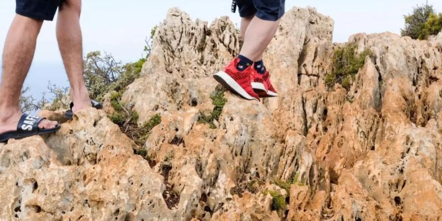 Mit Sportschuhen und Badelatschen auf felsigem Gelände zu wandern, kann schnell zu Verletzungen führen. Foto: Jens Kalaene