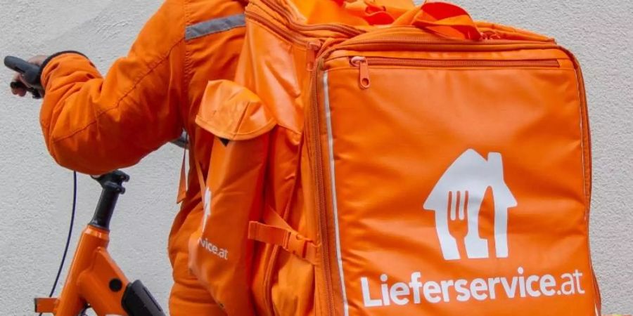 Ein Mitarbeiter von Lieferservice.at steht neben seinem E-Bike. Österreich hat den weltweit ersten Kollektivvertrag für Fahrradzusteller. Foto: Lukas Huter