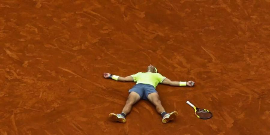 Nach seinem Sieg im Finale hat sich Rafael Nadal rücklings auf den Platz fallen lassen. Foto: Pavel Golovkin/AP